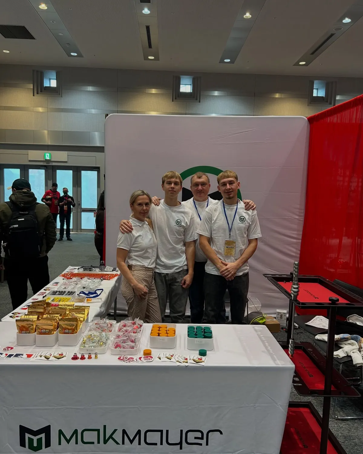 The Makmayer team at its booth at IASRE Japan 2024, with PDR glue and PrismTabs on the table