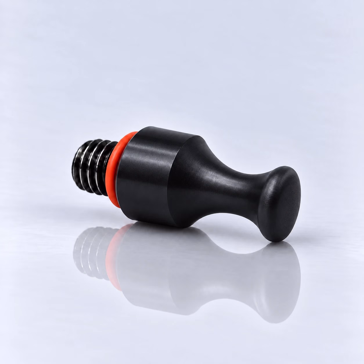 Wechselspitze Mittel – schwarze Wechselspitze aus Kunststoff mit mittelgroßem, abgeflachtem Kopf, rotem Gummiring und Zollgewinde, liegend